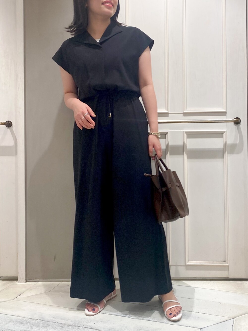 ブラック系のつなぎ/オールインワン、ブラウン系のショルダーバッグ、ホワイト系のサンダルを着用したレディースの夏コーディネートの2枚目の写真