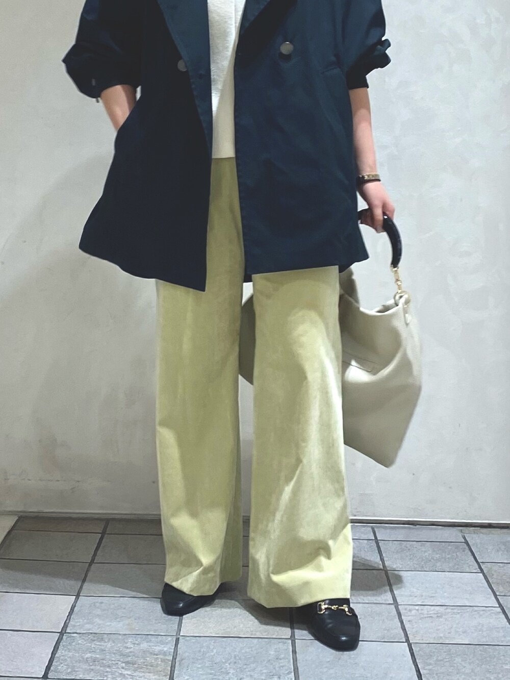 ホワイト系のTシャツ/カットソー、ブルー系のトレンチコート、グリーン系のその他パンツを着用したレディースの秋コーディネートの6枚目の写真