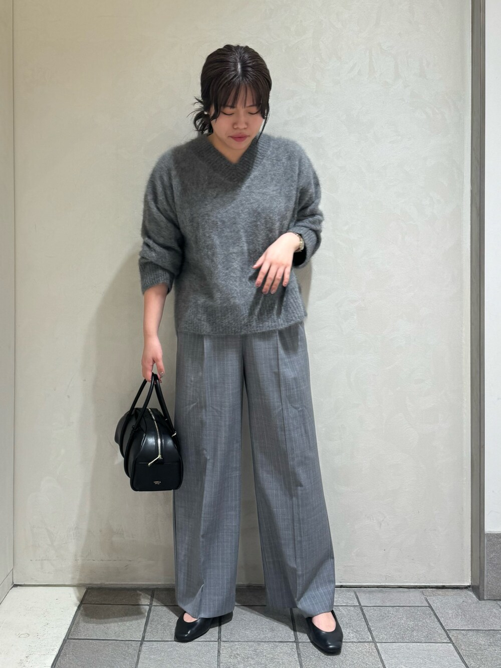 グレー系のニット/セーター、その他のスラックス、ブラック系のボストンバッグを着用したレディースの秋コーディネートの5枚目の写真