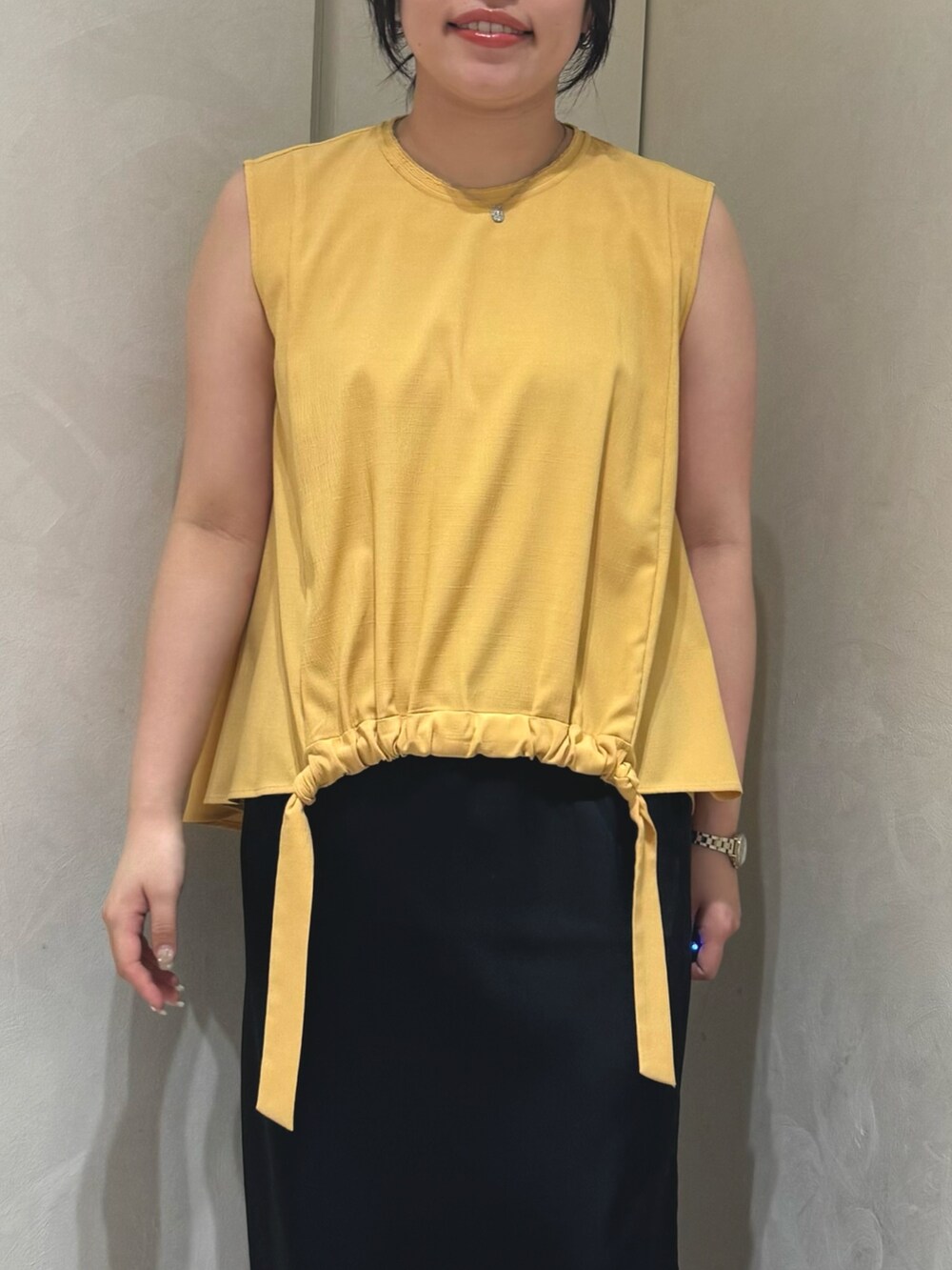 イエロー系のシャツ/ブラウス、ブラック系のスカートを着用したレディースの夏コーディネートの4枚目の写真