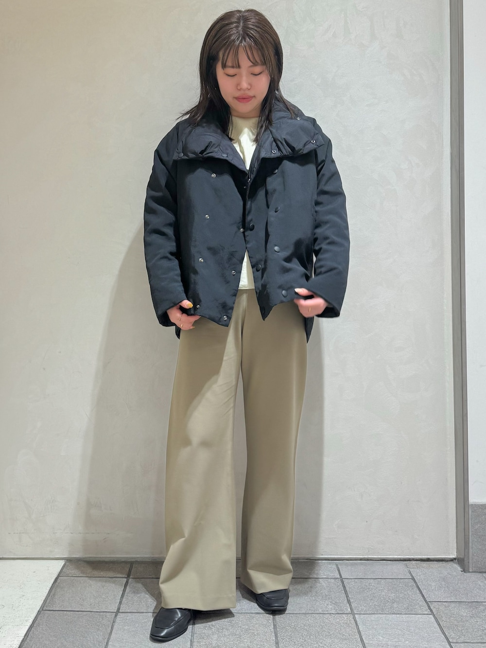 ブラック系のダウンジャケット/コート、グリーン系のスラックスを着用したレディースの秋コーディネートの3枚目の写真