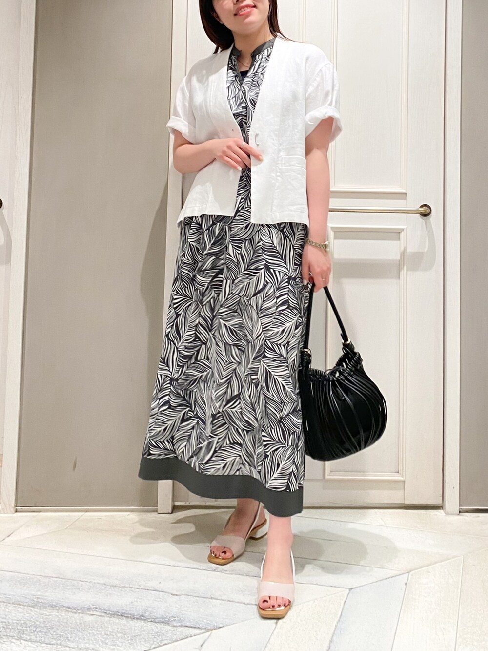 ホワイト系のノーカラージャケット、グレー系のワンピース、ホワイト系のショルダーバッグを着用したレディースの春コーディネートの4枚目の写真