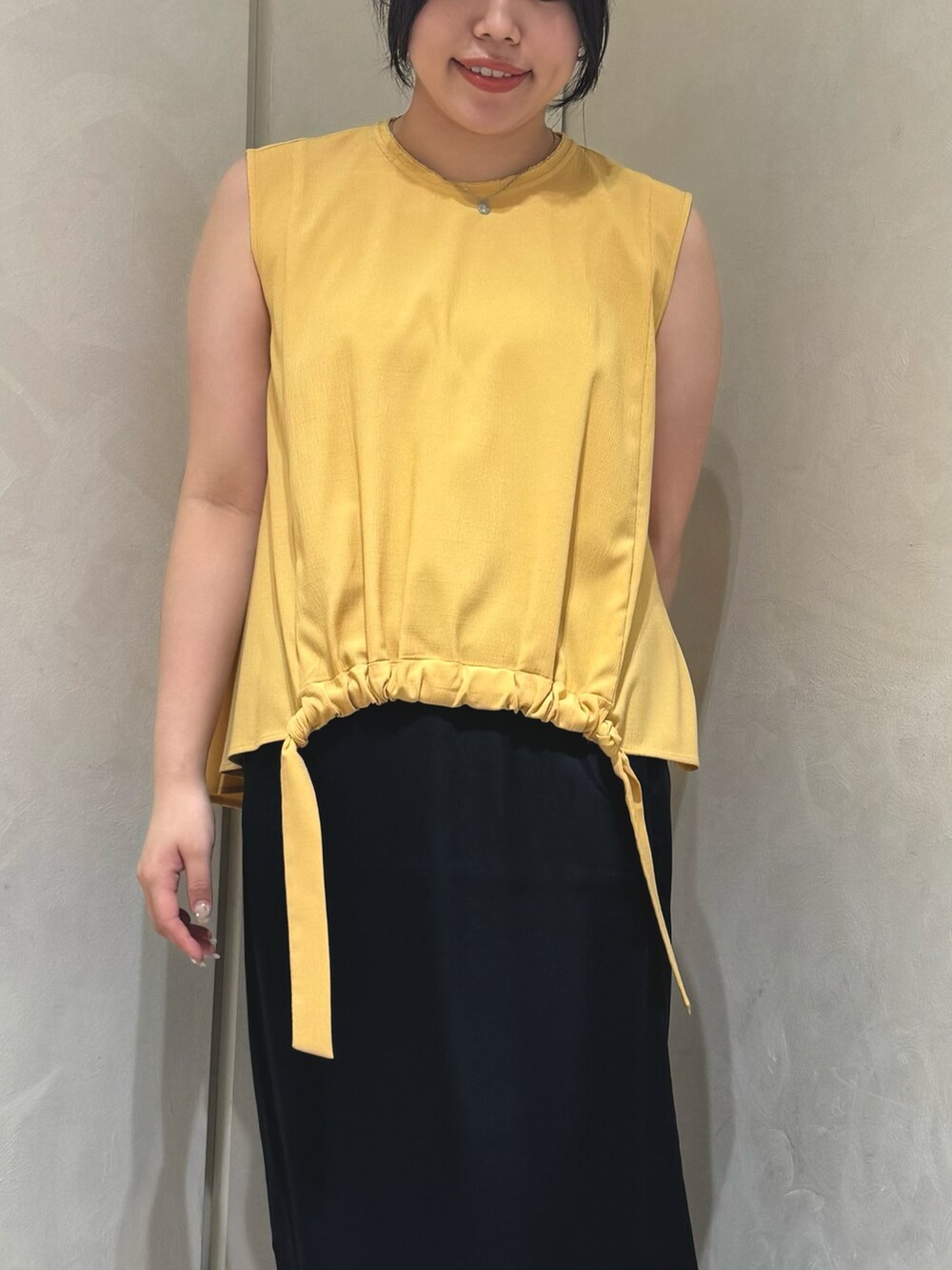 イエロー系のシャツ/ブラウス、ブラック系のスカートを着用したレディースの夏コーディネートの5枚目の写真