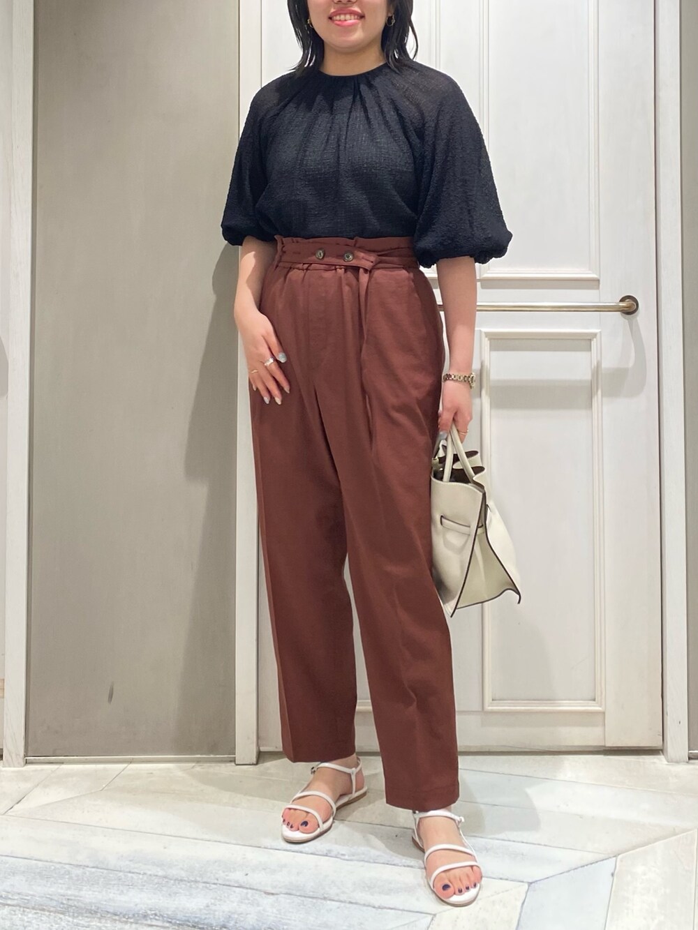 ブラック系のシャツ/ブラウス、レッド系のスラックス、ホワイト系のハンドバッグを着用したレディースの夏コーディネートの4枚目の写真