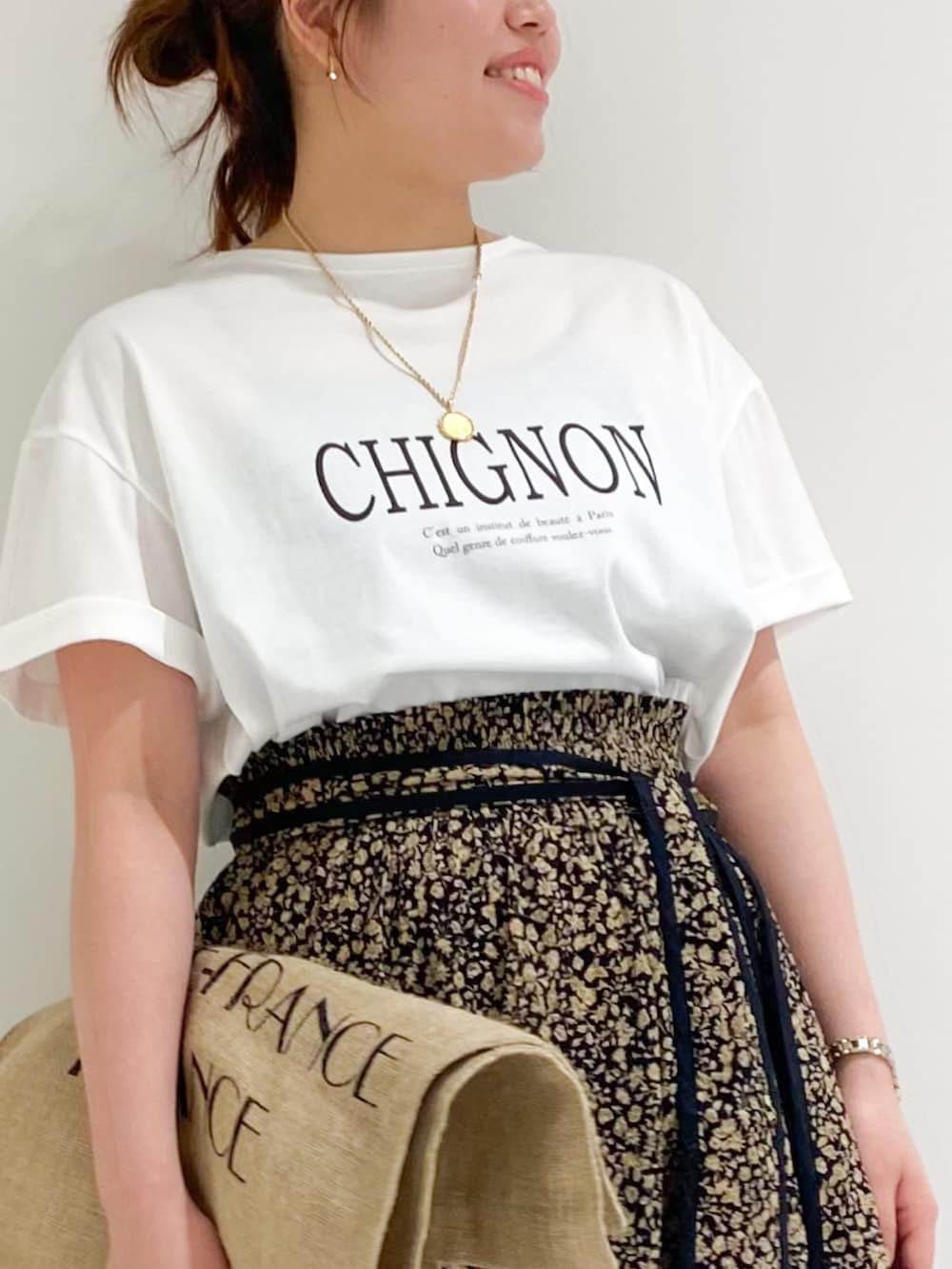 ブラウン系のTシャツ/カットソー、ブラック系のトートバッグ、ブラック系のスカートを着用したレディースの春コーディネートの5枚目の写真