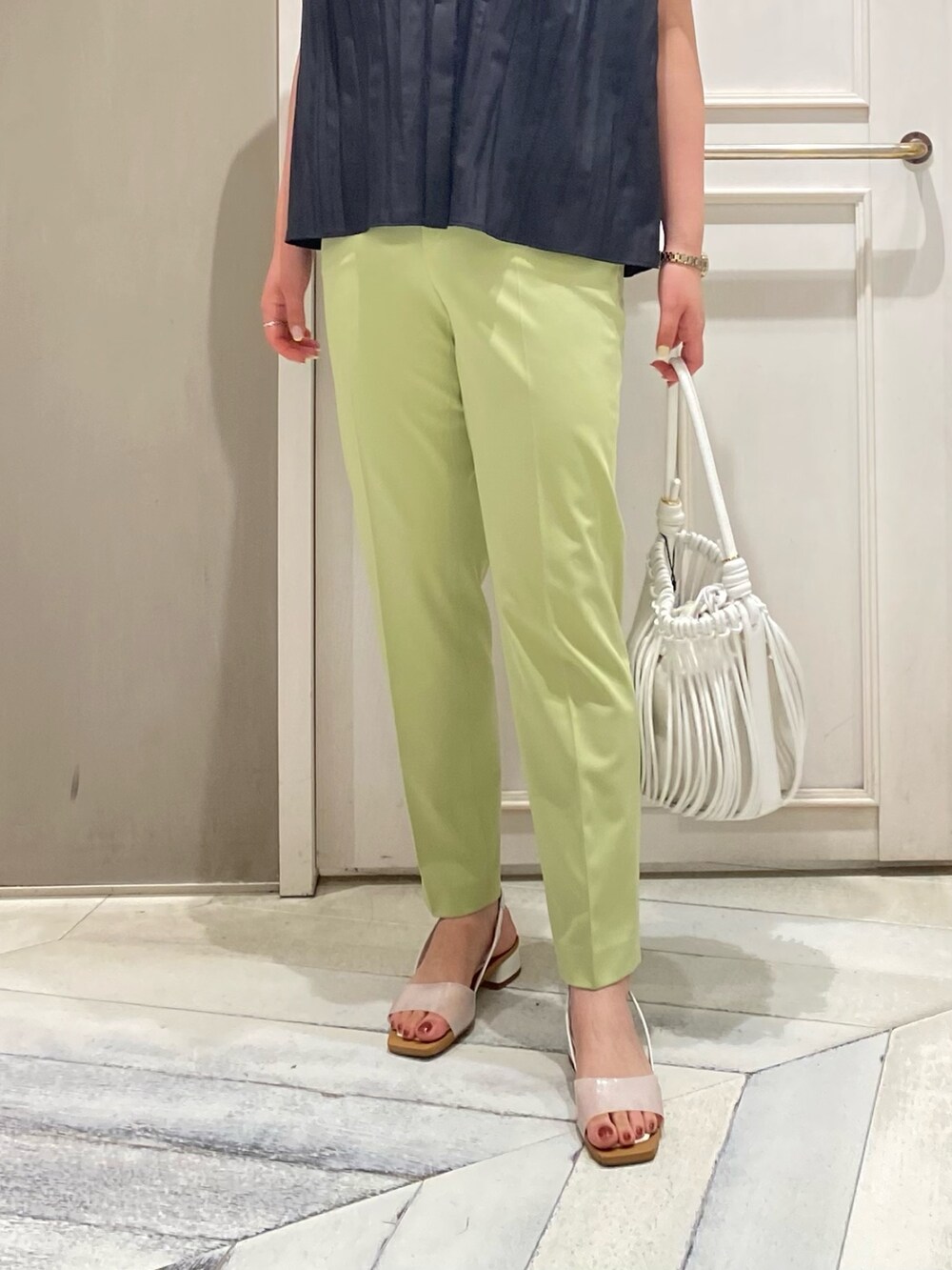 ブラック系のシャツ/ブラウス、グリーン系のスラックス、ホワイト系のサンダルを着用したレディースの夏コーディネートの5枚目の写真