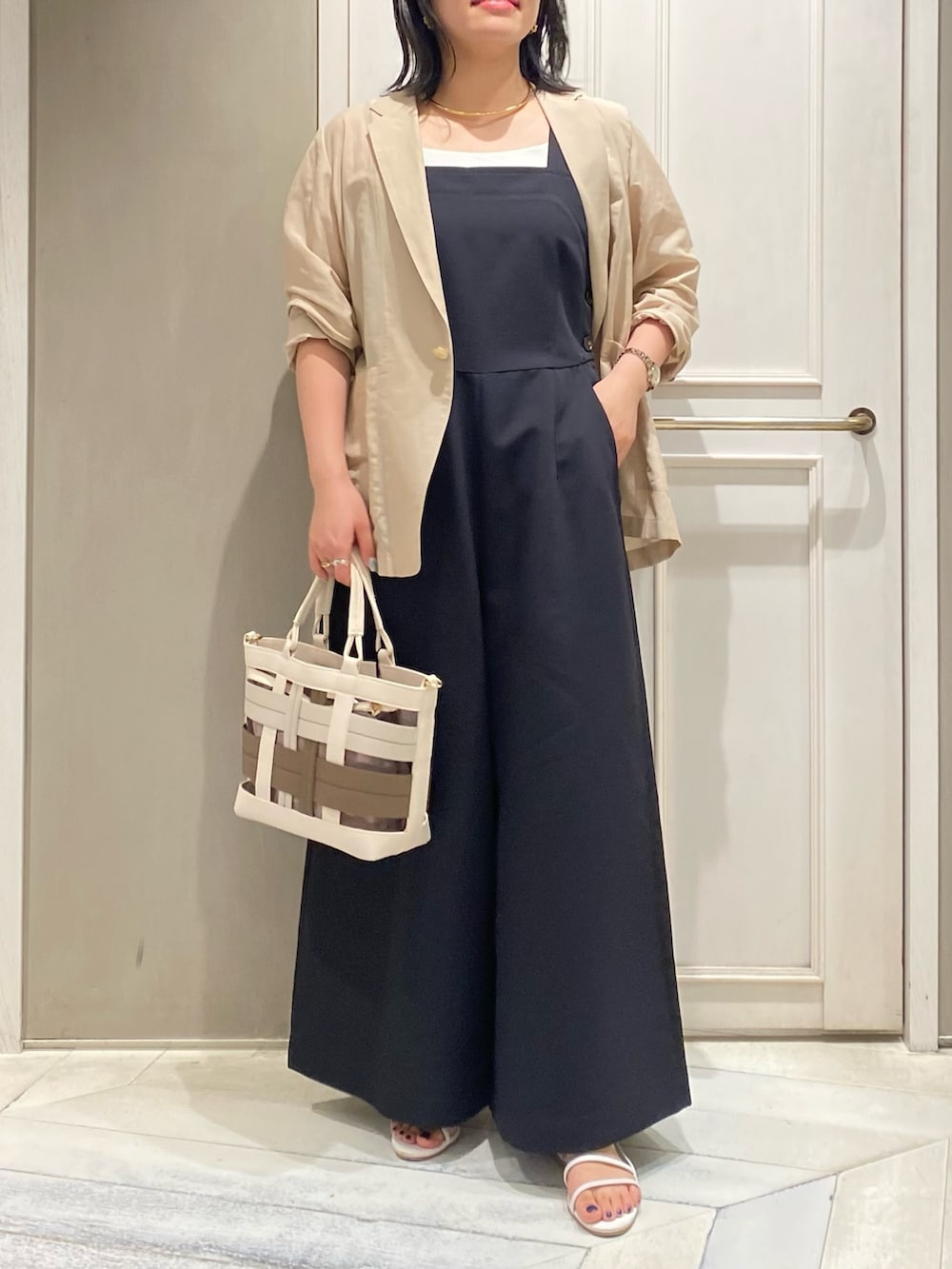 ブラック系のつなぎ/オールインワン、ベージュ系のテーラードジャケット、ベージュ系のハンドバッグを着用したレディースの夏コーディネートの3枚目の写真