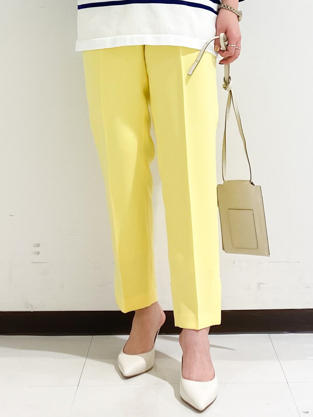 ブルー系のニット/セーター、ホワイト系のショルダーバッグ、ブラック系のパンプスを着用したレディースの冬コーディネートの4枚目の写真