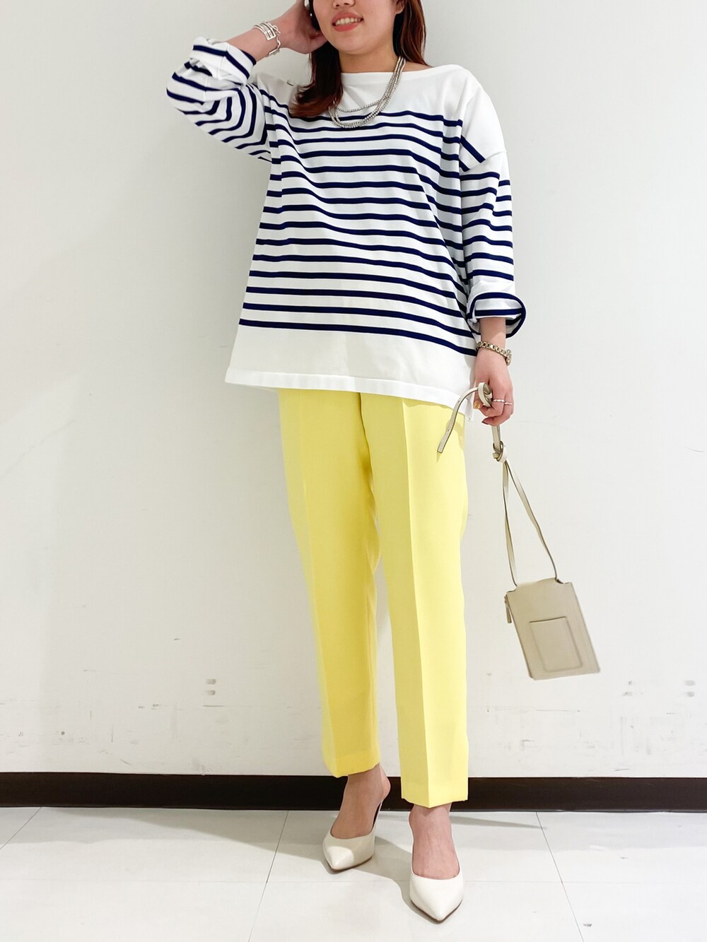 ブルー系のニット/セーター、ホワイト系のショルダーバッグ、ブラック系のパンプスを着用したレディースの冬コーディネートの2枚目の写真