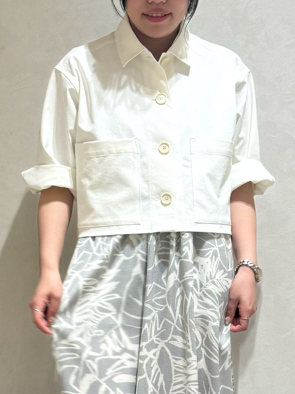 ホワイト系のブルゾン、グレー系のワンピースを着用したレディースの夏コーディネートの5枚目の写真