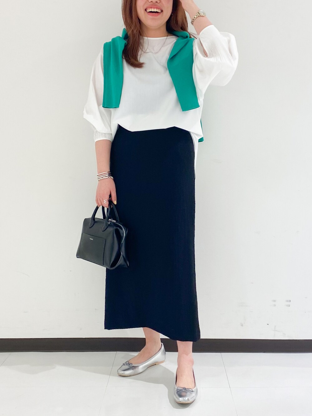 ホワイト系のシャツ/ブラウス、ブラック系のスカートを着用したレディースの春コーディネートの2枚目の写真