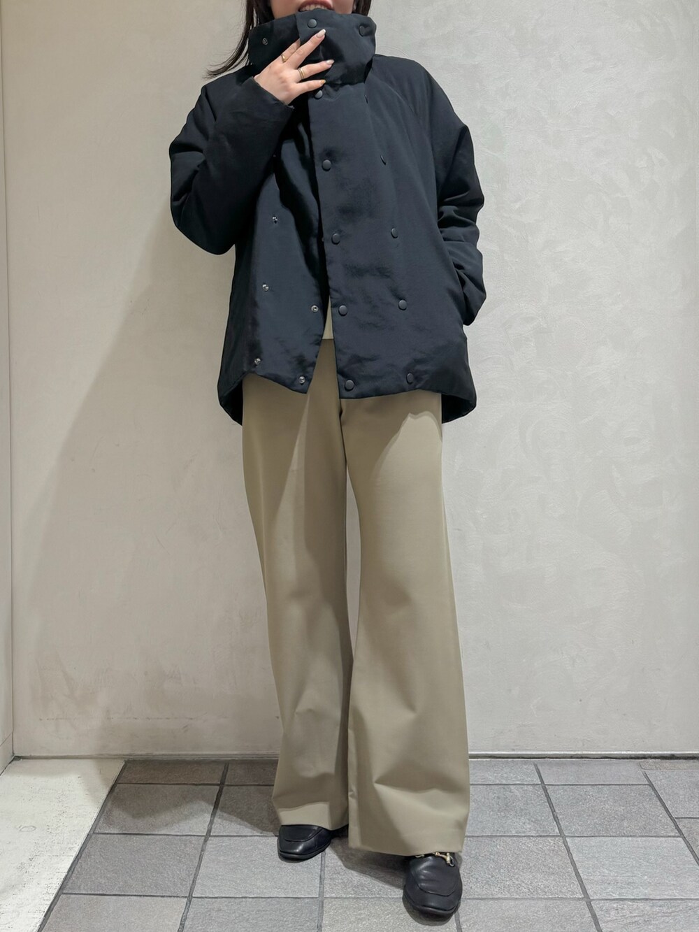 ブラック系のダウンジャケット/コート、グリーン系のスラックスを着用したレディースの秋コーディネートの8枚目の写真