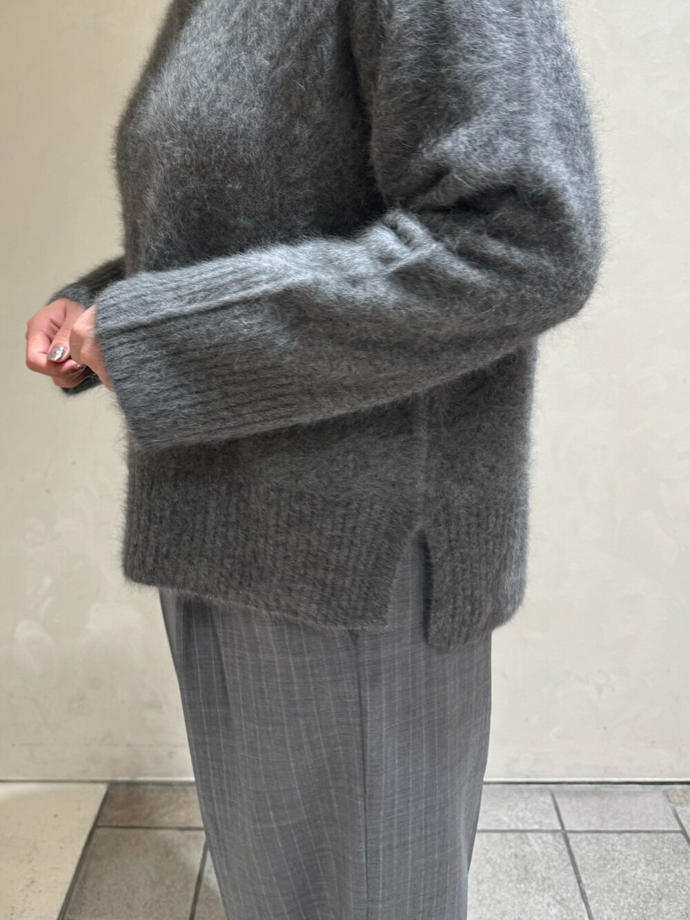 グレー系のニット/セーター、その他のスラックス、ブラック系のボストンバッグを着用したレディースの秋コーディネートの10枚目の写真