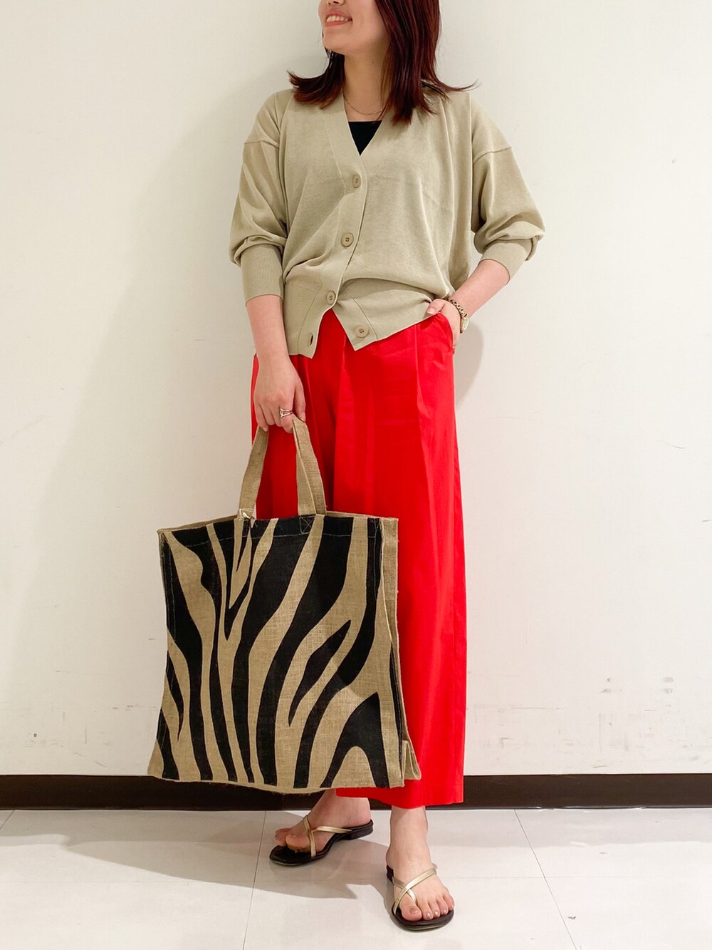 ベージュ系のカーディガン/ボレロ、レッド系のその他パンツ、ブラック系のトートバッグを着用したレディースの夏コーディネートの3枚目の写真