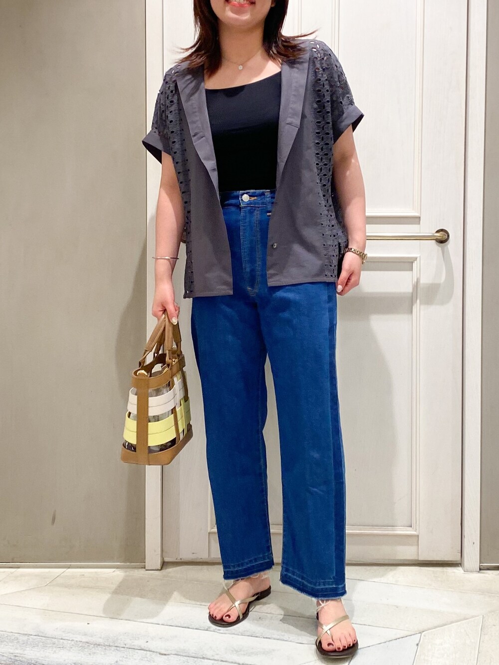 グレー系のシャツ/ブラウス、ブルー系のデニムパンツ、イエロー系のハンドバッグを着用したレディースの夏コーディネートの5枚目の写真