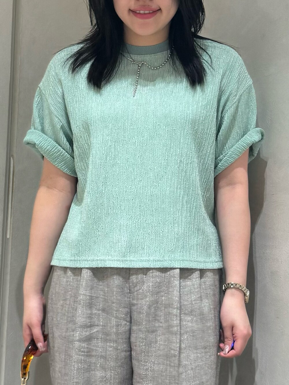 グリーン系のTシャツ/カットソー、グレー系のスラックス、ホワイト系のトートバッグを着用したレディースの夏コーディネートの6枚目の写真