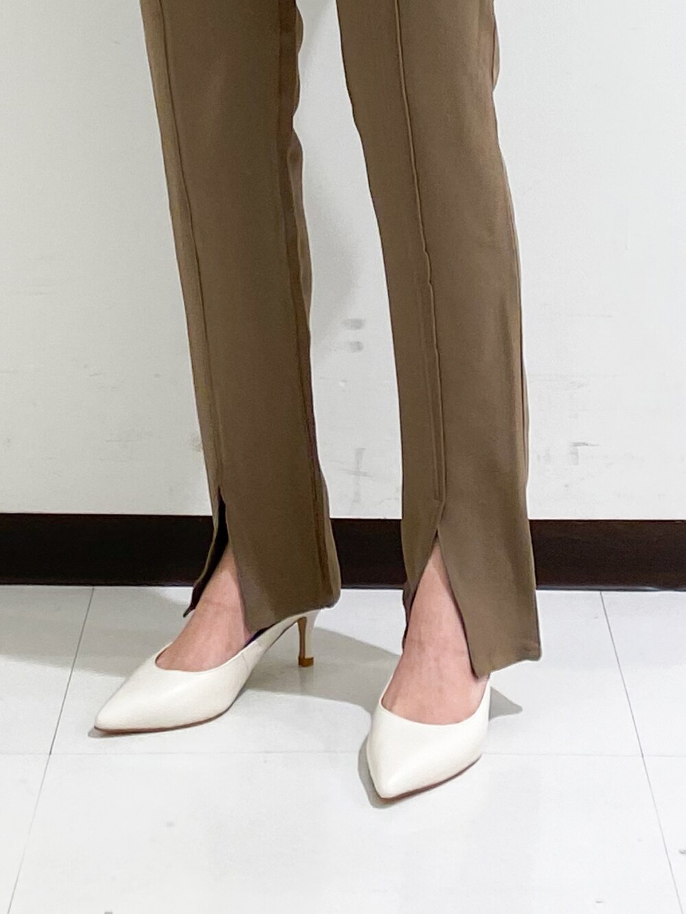 ホワイト系のシャツ/ブラウス、ブラウン系のその他パンツ、ブラック系のパンプスを着用したレディースの秋コーディネートの5枚目の写真