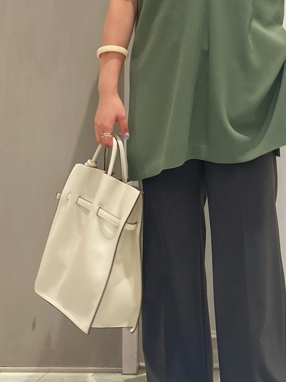 グリーン系のベスト、ホワイト系のTシャツ/カットソー、ホワイト系のトートバッグを着用したレディースの夏コーディネートの5枚目の写真