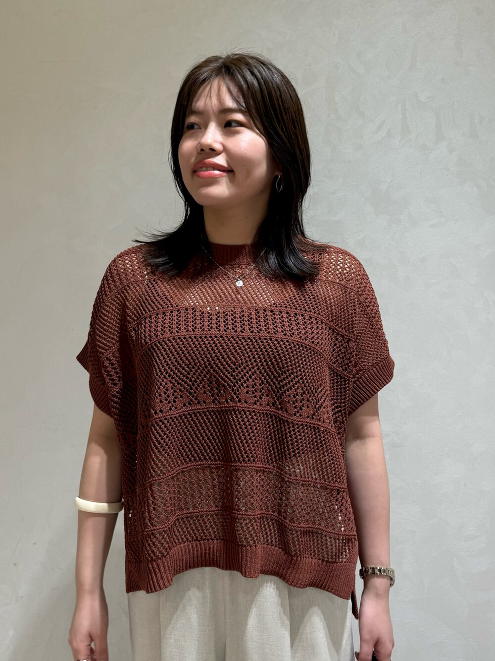 ブラウン系のニット/セーター、ホワイト系のトートバッグを着用したレディースの夏コーディネートの6枚目の写真