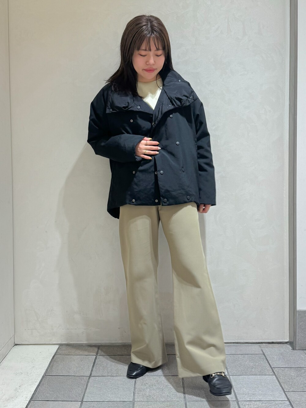 ブラック系のダウンジャケット/コート、グリーン系のスラックスを着用したレディースの秋コーディネートの9枚目の写真