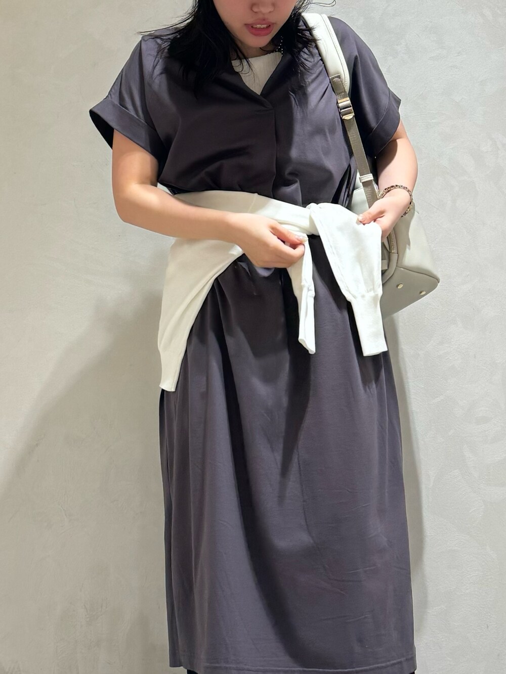 グレー系のワンピース、ブラック系のバックパック/リュック、ホワイト系のカーディガン/ボレロを着用したレディースの夏コーディネートの6枚目の写真