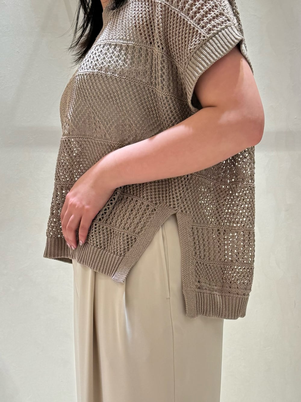 ベージュ系のニット/セーター、ホワイト系のスラックスを着用したレディースの春コーディネートの4枚目の写真