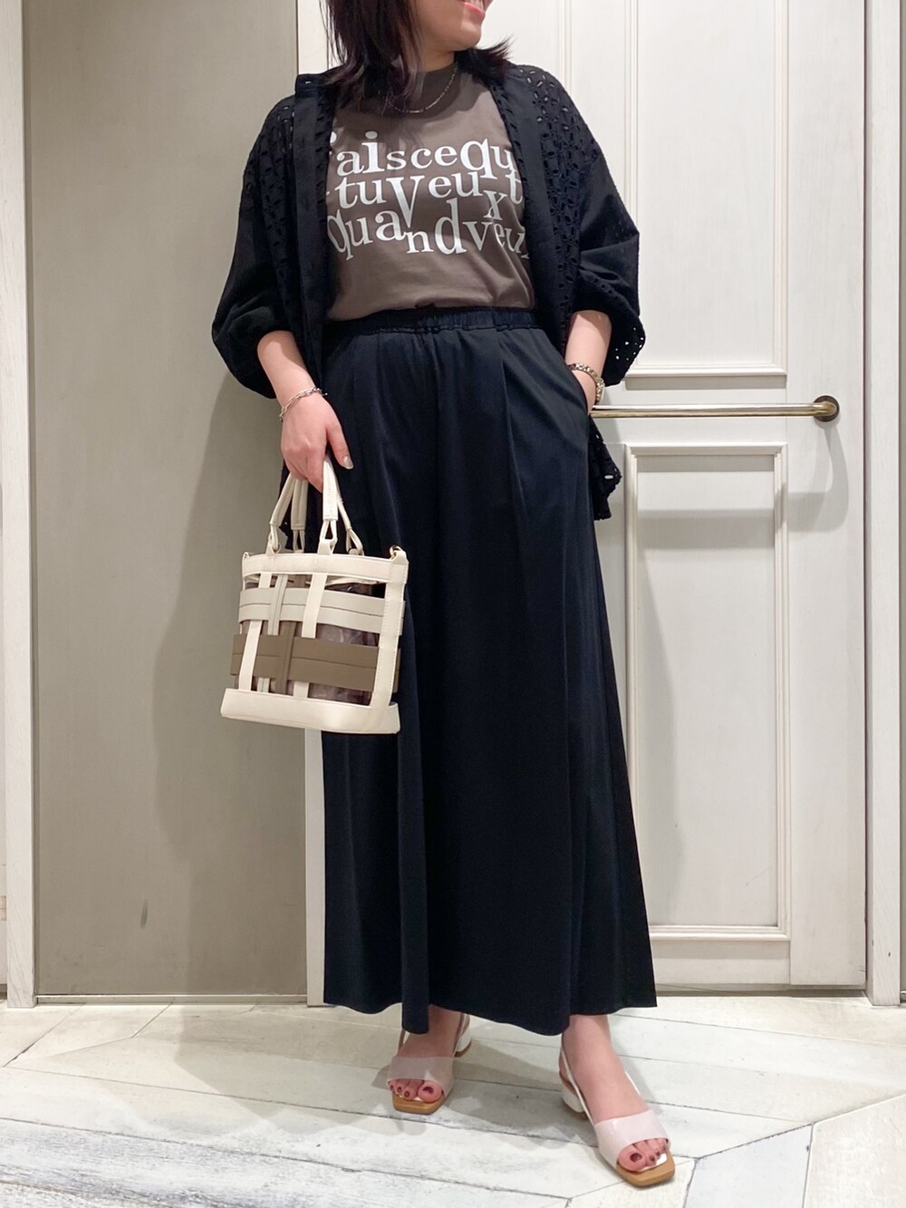 グレー系のTシャツ/カットソー、ブラック系のシャツ/ブラウス、ベージュ系のハンドバッグを着用したレディースの春コーディネートの2枚目の写真