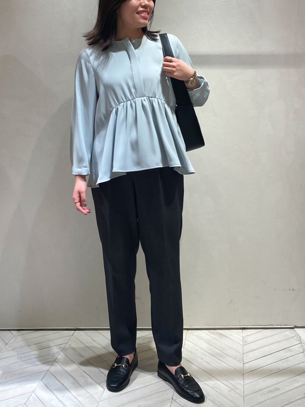 ブルー系のシャツ/ブラウス、グレー系のスラックスを着用したレディースの秋コーディネートの2枚目の写真