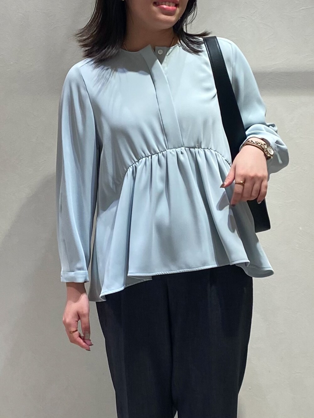 ブルー系のシャツ/ブラウス、グレー系のスラックスを着用したレディースの秋コーディネートの4枚目の写真