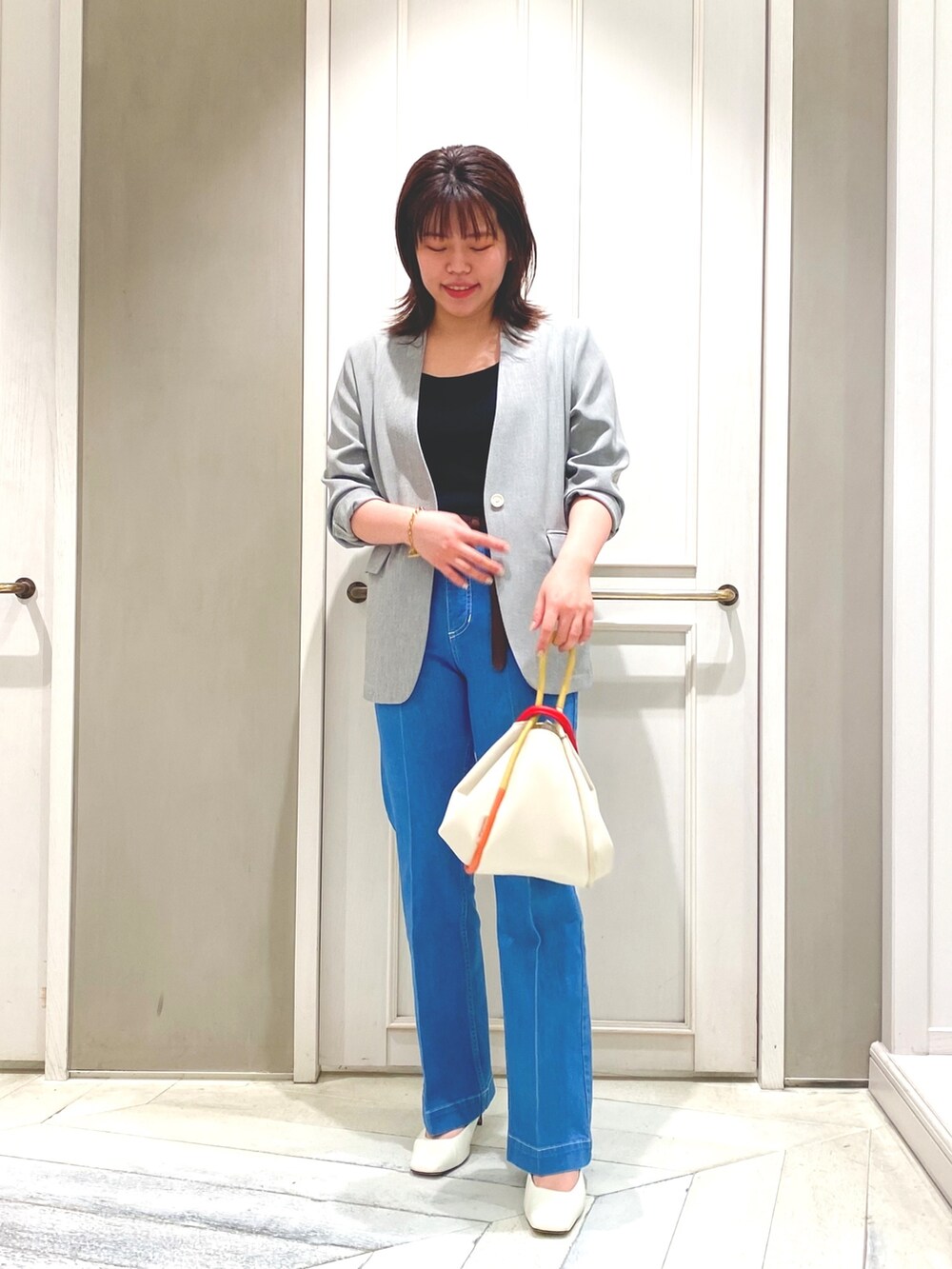 ブラック系のタンクトップ、ブルー系のデニムパンツ、ブラック系のノーカラージャケットを着用したレディースの春コーディネートの2枚目の写真