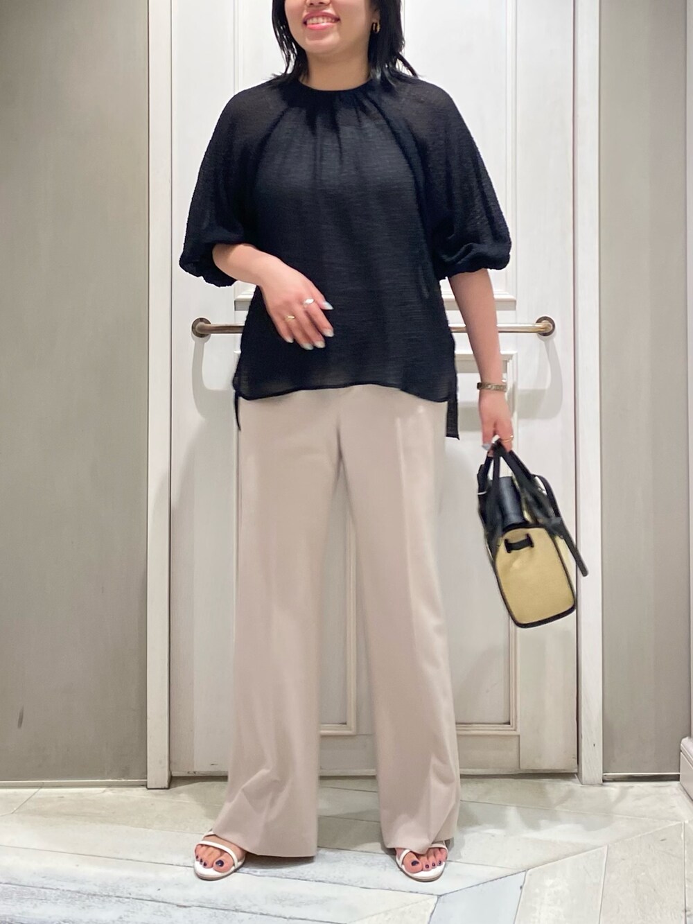 ブラック系のシャツ/ブラウス、ブラック系のトートバッグ、ピンク系のスラックスを着用したレディースの夏コーディネートの2枚目の写真
