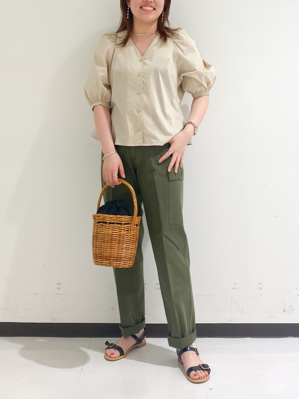 ベージュ系のシャツ/ブラウス、グリーン系のカーゴパンツ、ブラック系のかごバッグを着用したレディースの春コーディネートの2枚目の写真
