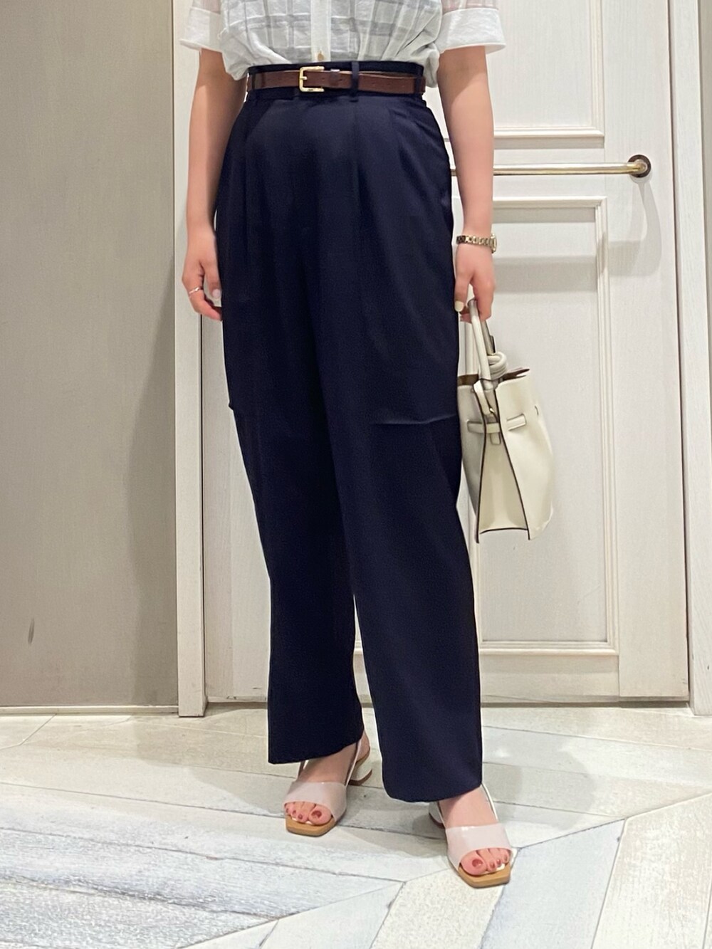 グリーン系のトートバッグ、ホワイト系のサンダル、ホワイト系のニット/セーターを着用したレディースの夏コーディネートの5枚目の写真