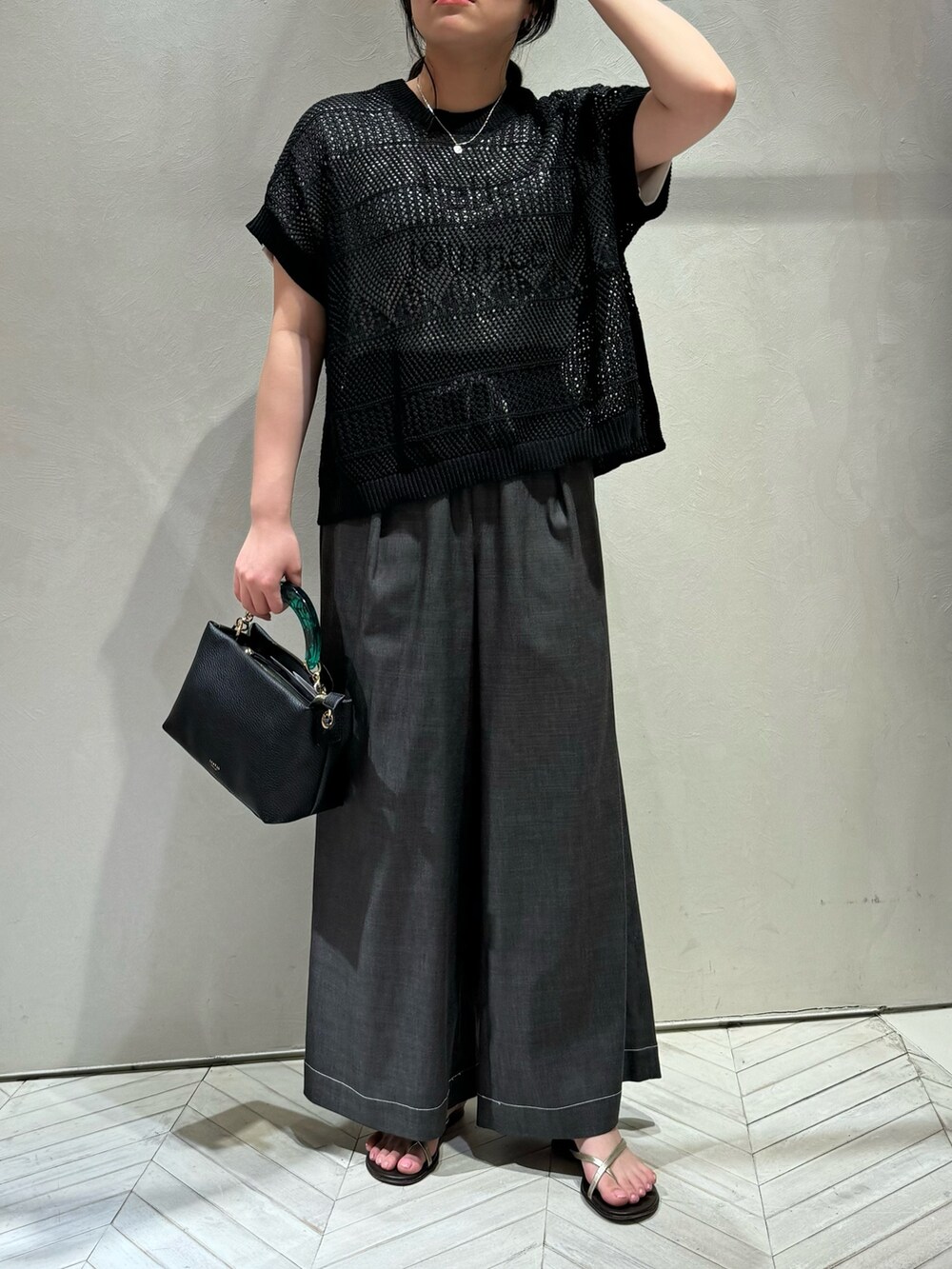 ブラック系のニット/セーター、ブラック系のデニムパンツを着用したレディースの春コーディネートの3枚目の写真