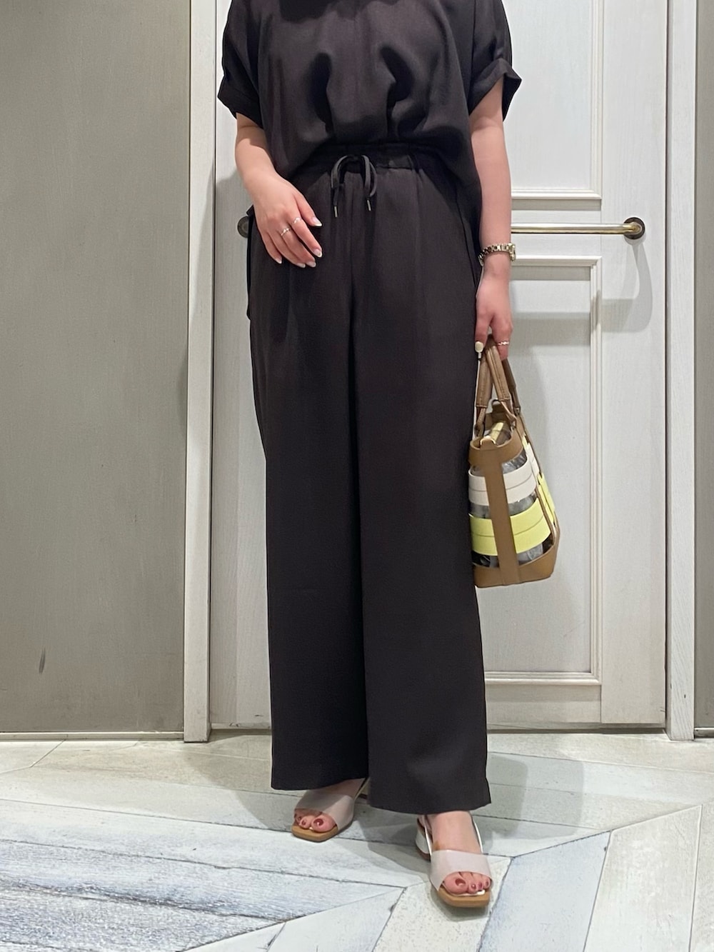 ブラウン系のシャツ/ブラウス、イエロー系のハンドバッグ、ホワイト系のサンダルを着用したレディースの夏コーディネートの4枚目の写真