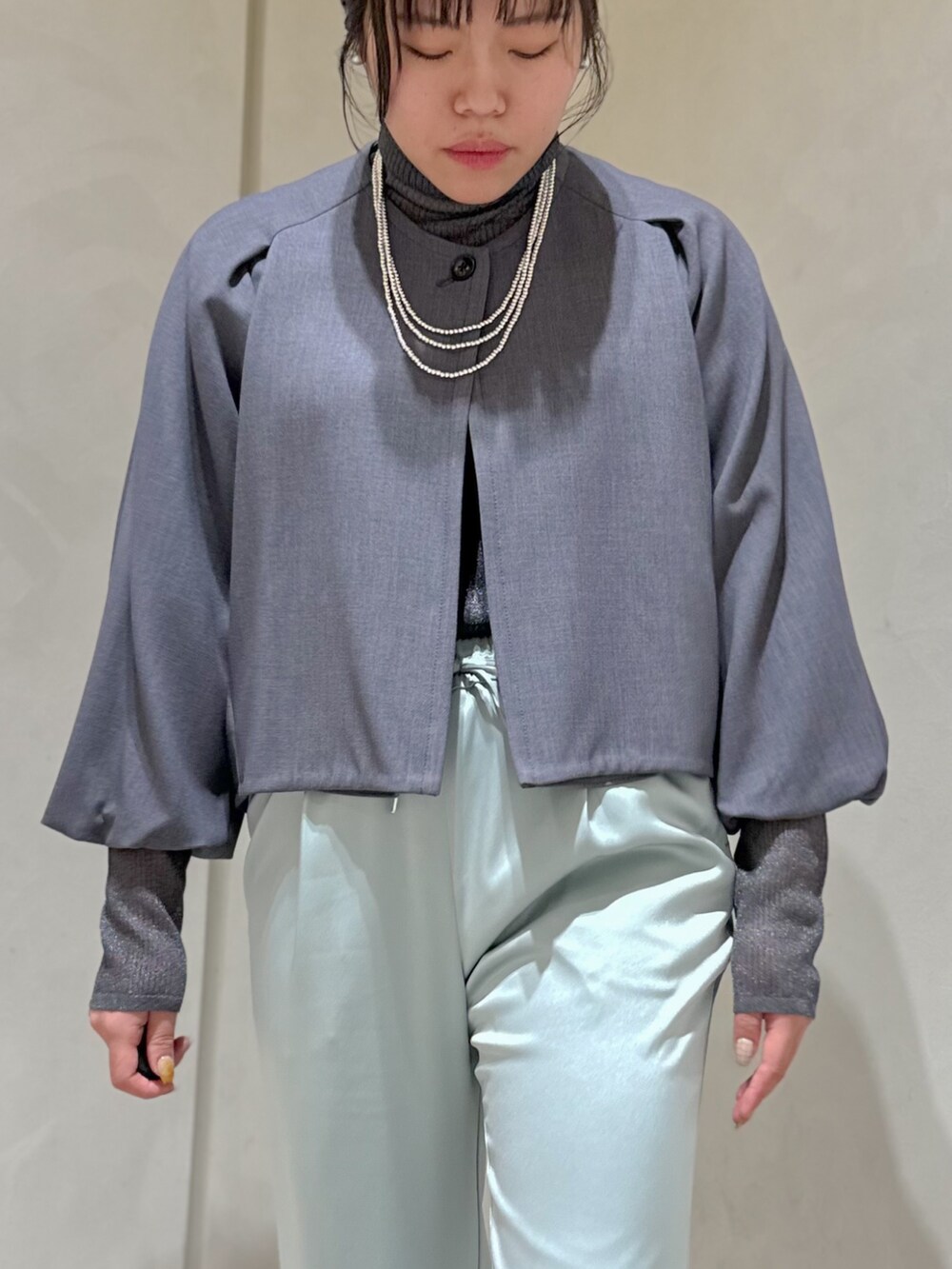 グリーン系のスラックス、グレー系のニット/セーター、グレー系のテーラードジャケットを着用したレディースの秋コーディネートの6枚目の写真