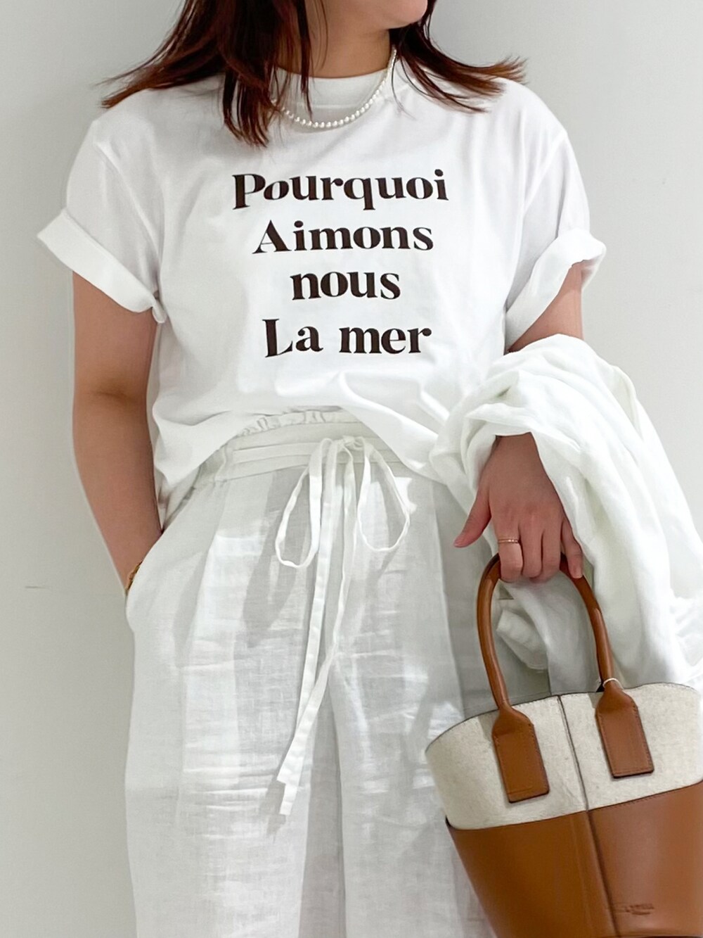 ブラウン系のTシャツ/カットソー、イエロー系のショルダーバッグ、ホワイト系のその他パンツを着用したレディースの夏コーディネートの2枚目の写真