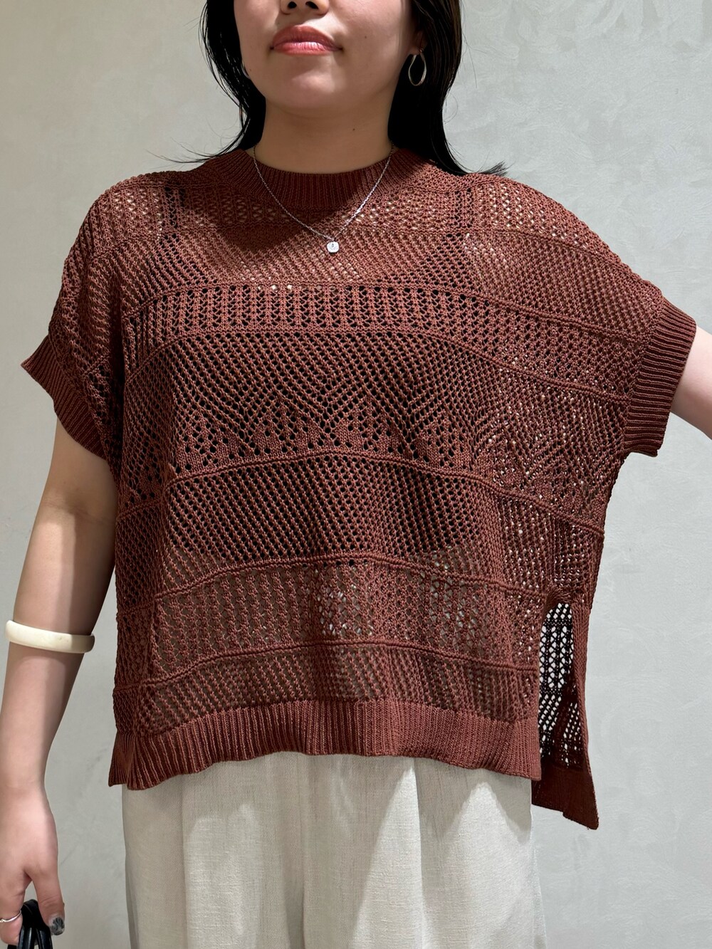 ブラウン系のニット/セーター、ホワイト系のトートバッグを着用したレディースの夏コーディネートの7枚目の写真