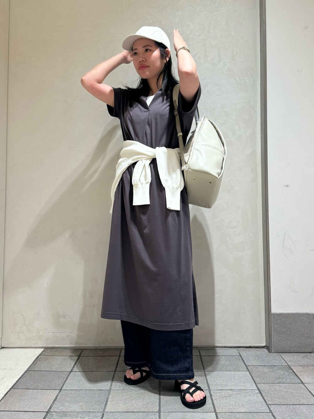 グレー系のワンピース、ブラック系のバックパック/リュック、ホワイト系のカーディガン/ボレロを着用したレディースの夏コーディネートの7枚目の写真