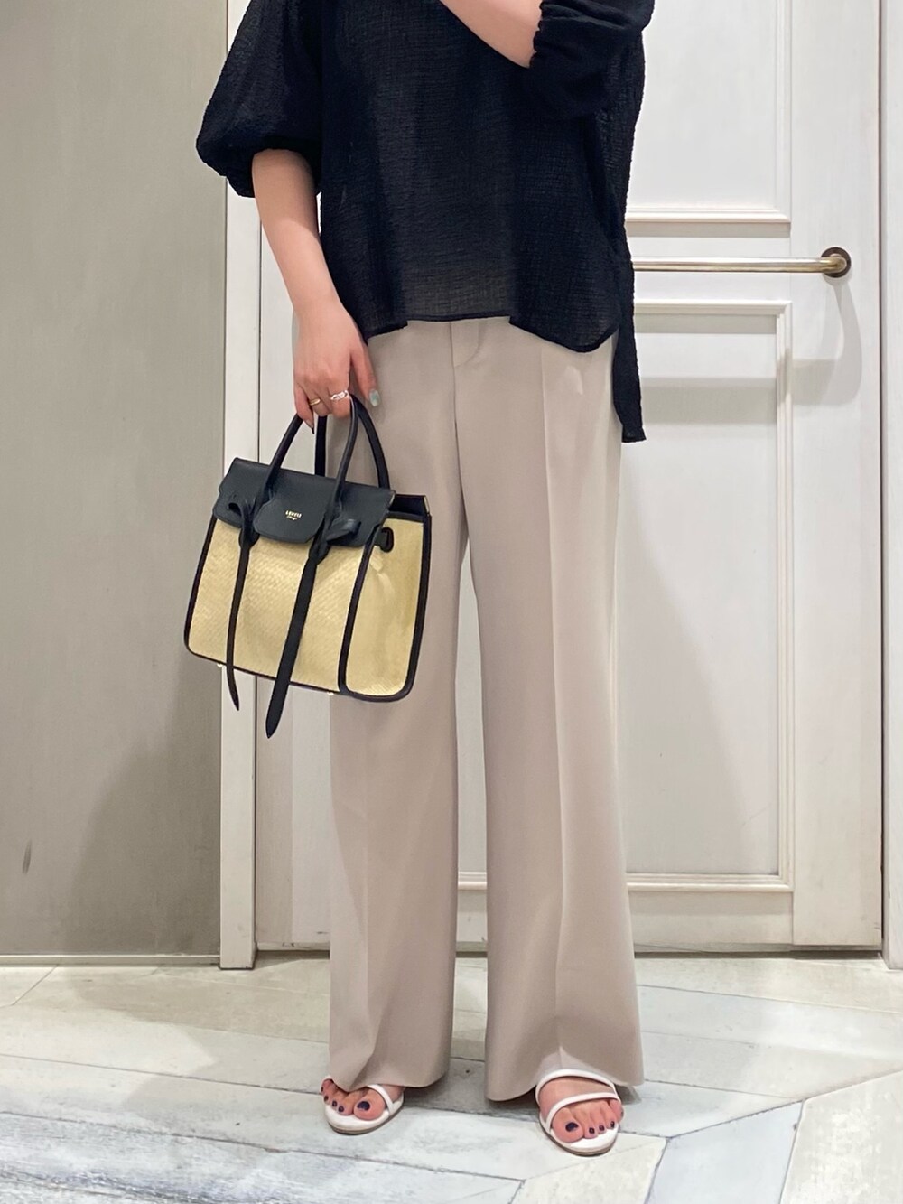 ブラック系のシャツ/ブラウス、ブラック系のトートバッグ、ピンク系のスラックスを着用したレディースの夏コーディネートの3枚目の写真