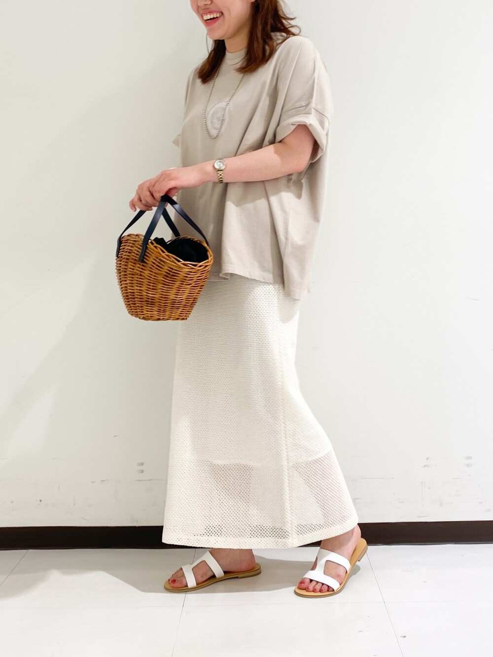 ベージュ系のTシャツ/カットソー、ホワイト系のスカート、ホワイト系のパンプスを着用したレディースの春コーディネートの2枚目の写真