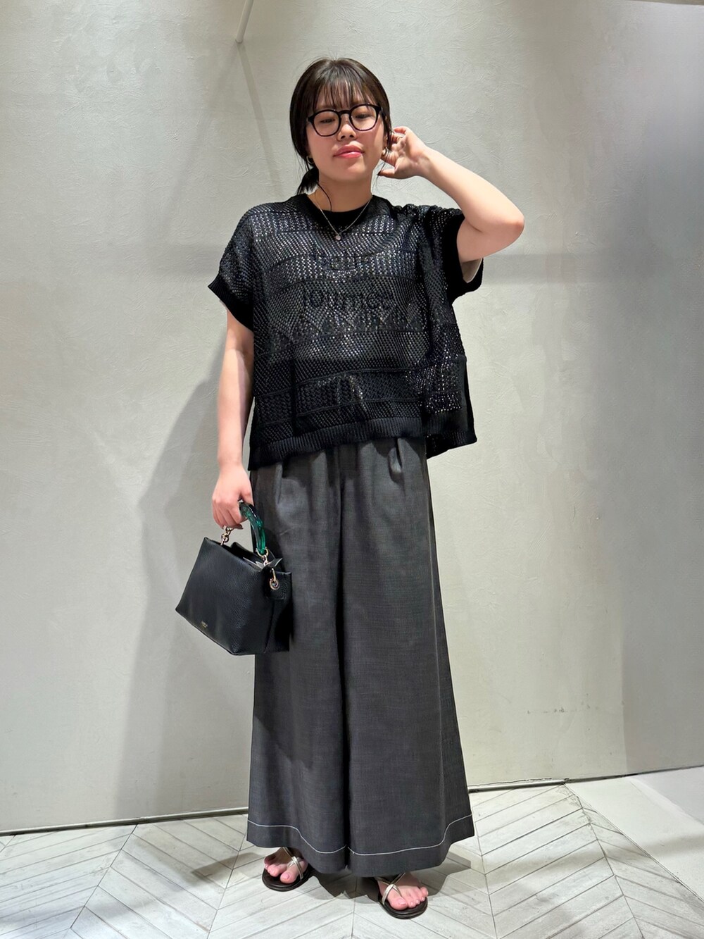 ブラック系のニット/セーター、ブラック系のデニムパンツを着用したレディースの春コーディネートの2枚目の写真