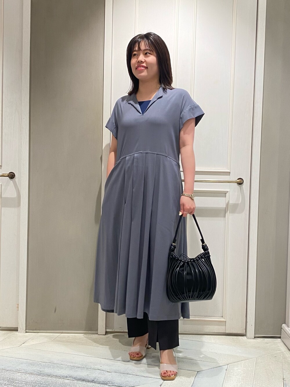 グレー系のワンピース、ホワイト系のサンダル、グレー系のスラックスを着用したレディースの夏コーディネートの5枚目の写真