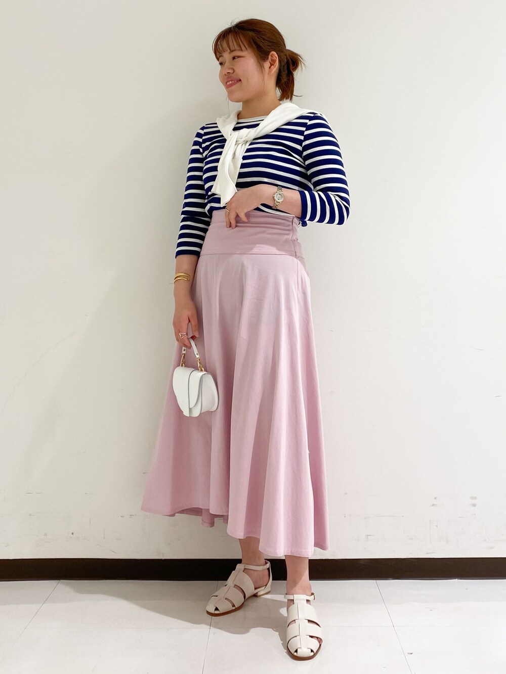 ブルー系のTシャツ/カットソー、ピンク系のスカート、ホワイト系のサンダルを着用したレディースの春コーディネートの2枚目の写真