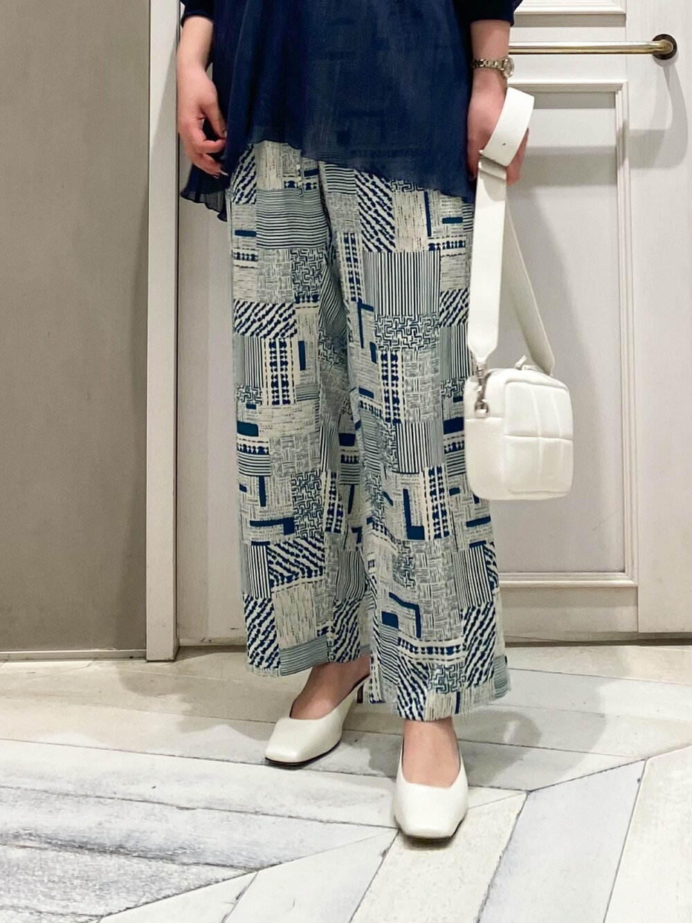 ブルー系のTシャツ/カットソー、グリーン系のその他パンツ、ホワイト系のショルダーバッグを着用したレディースの春コーディネートの2枚目の写真