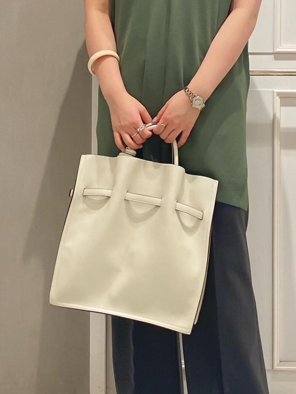 グリーン系のベスト、ホワイト系のTシャツ/カットソー、ホワイト系のトートバッグを着用したレディースの夏コーディネートの4枚目の写真