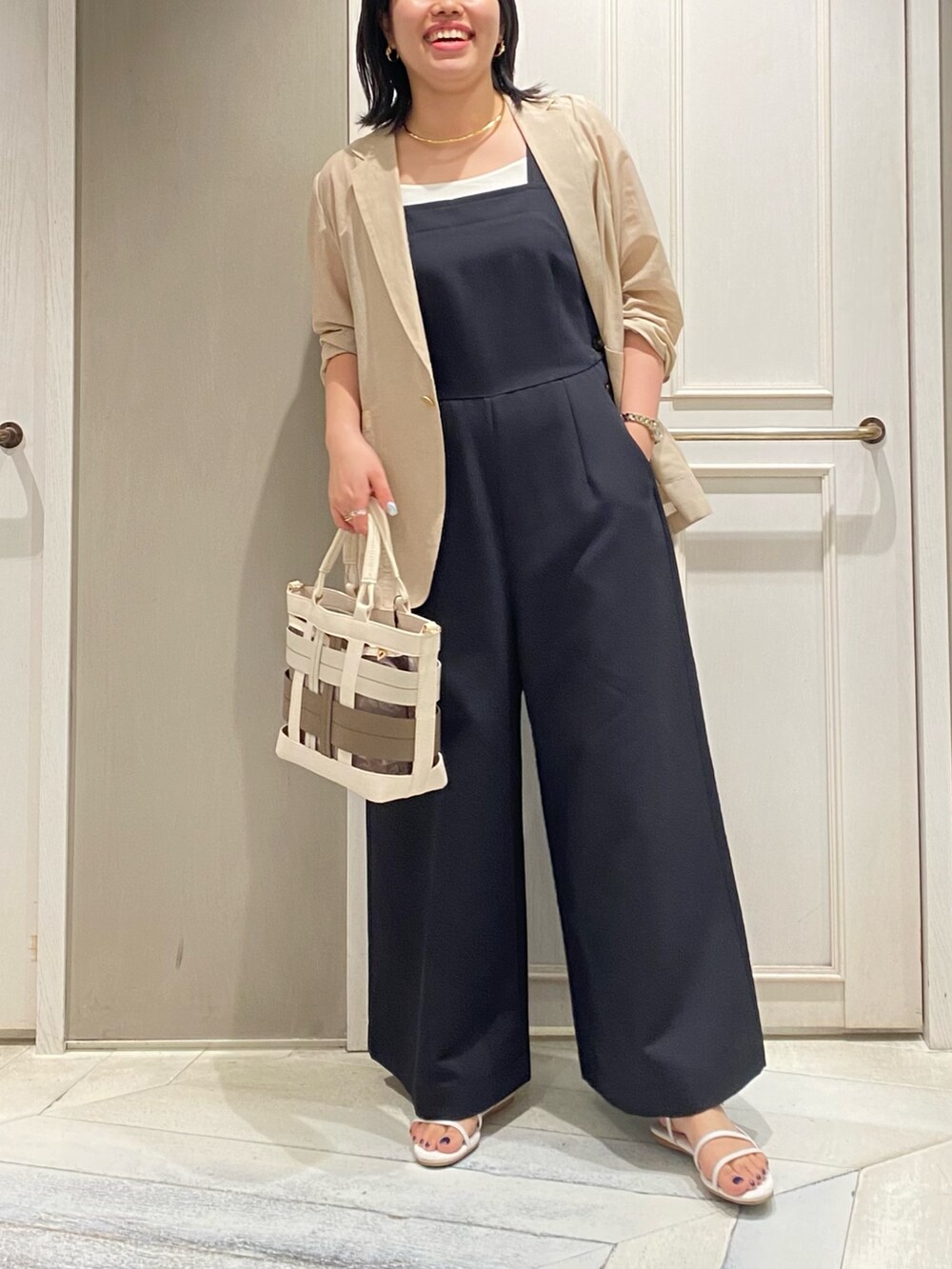 ブラック系のつなぎ/オールインワン、ベージュ系のテーラードジャケット、ベージュ系のハンドバッグを着用したレディースの夏コーディネートの5枚目の写真