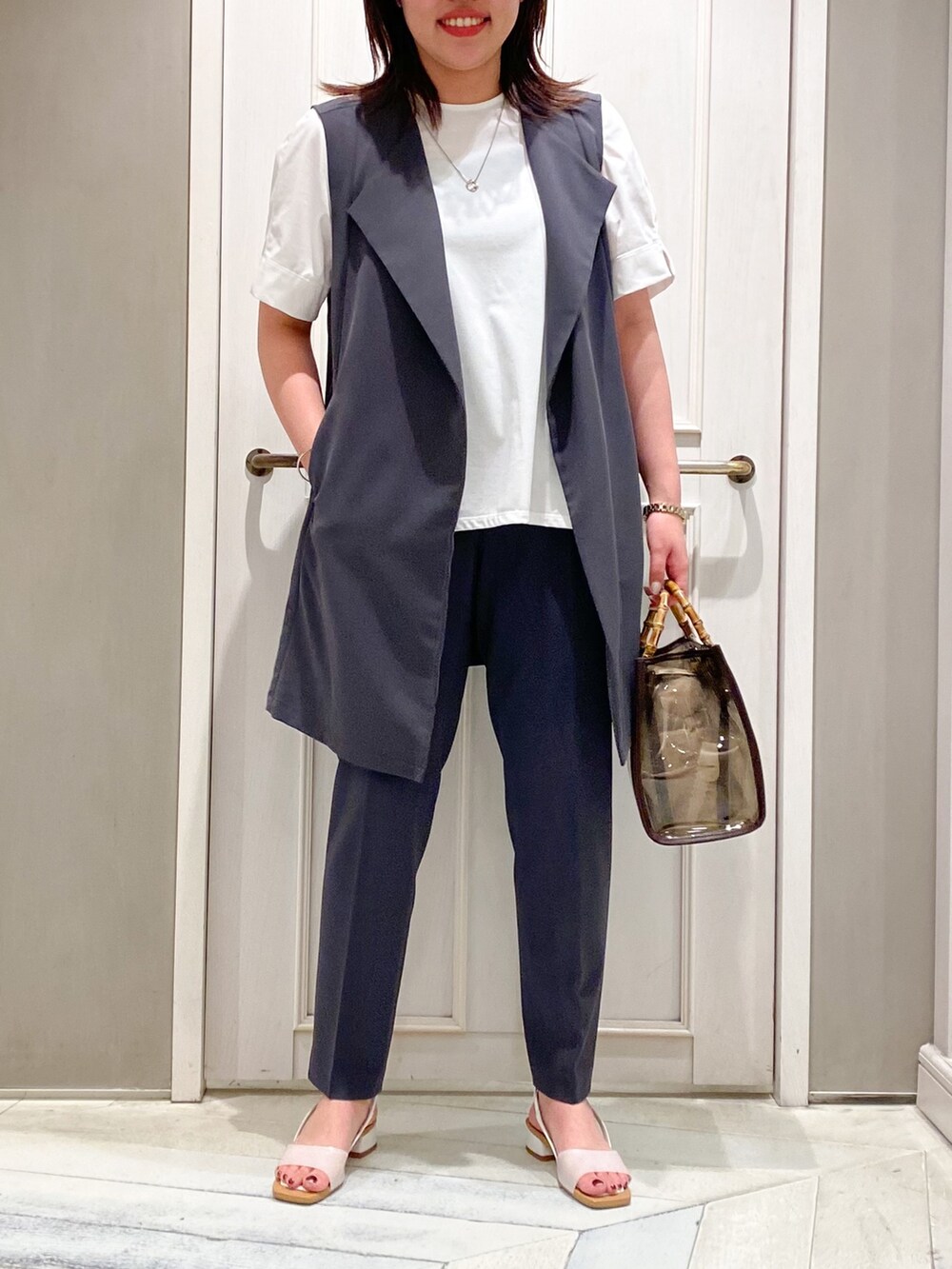 ホワイト系のTシャツ/カットソー、ブラウン系のトートバッグ、ホワイト系のサンダルを着用したレディースの夏コーディネートの3枚目の写真