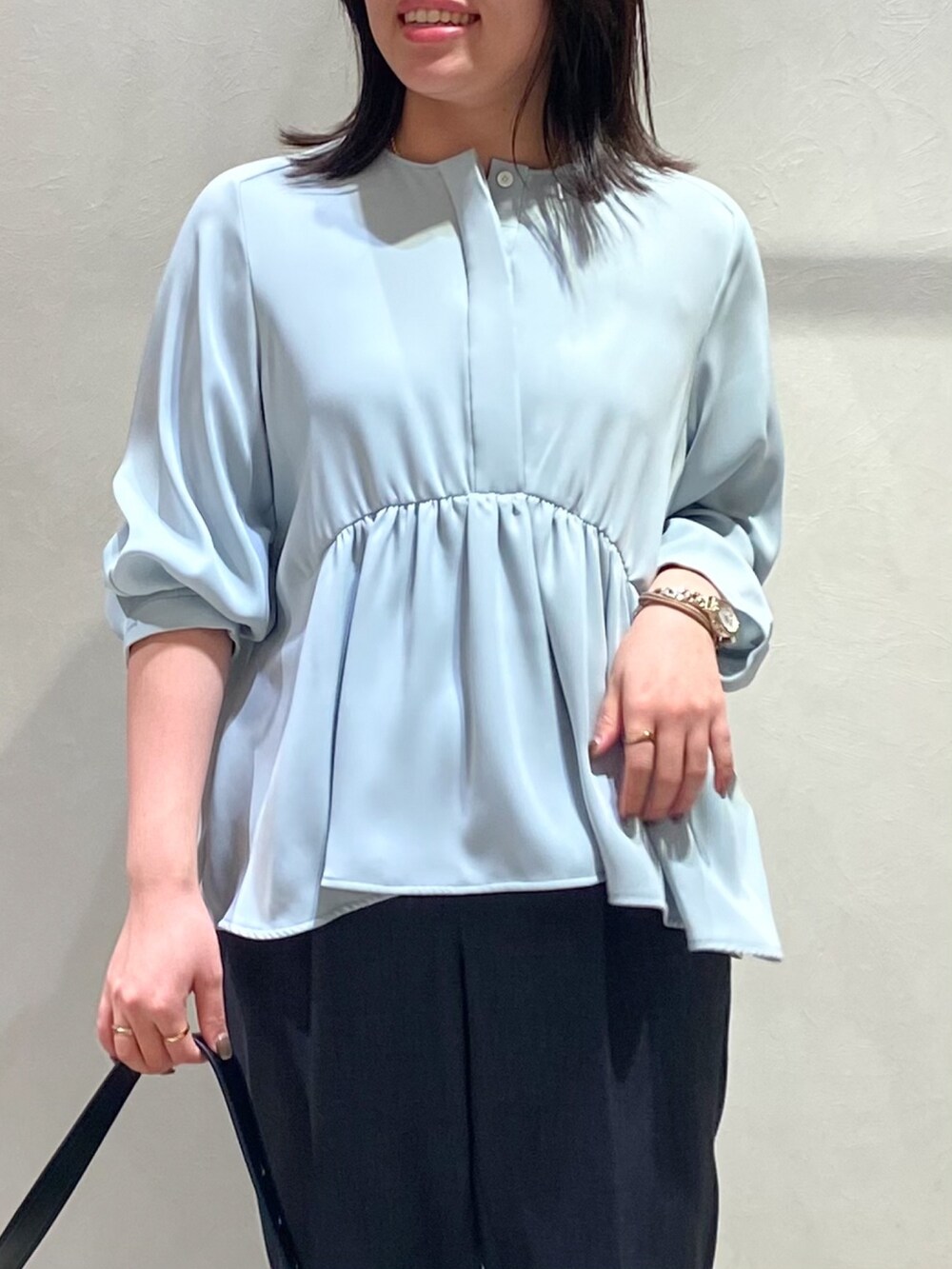 ブルー系のシャツ/ブラウス、グレー系のスラックスを着用したレディースの秋コーディネートの5枚目の写真