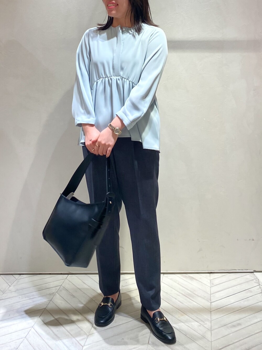 ブルー系のシャツ/ブラウス、グレー系のスラックスを着用したレディースの秋コーディネートの3枚目の写真